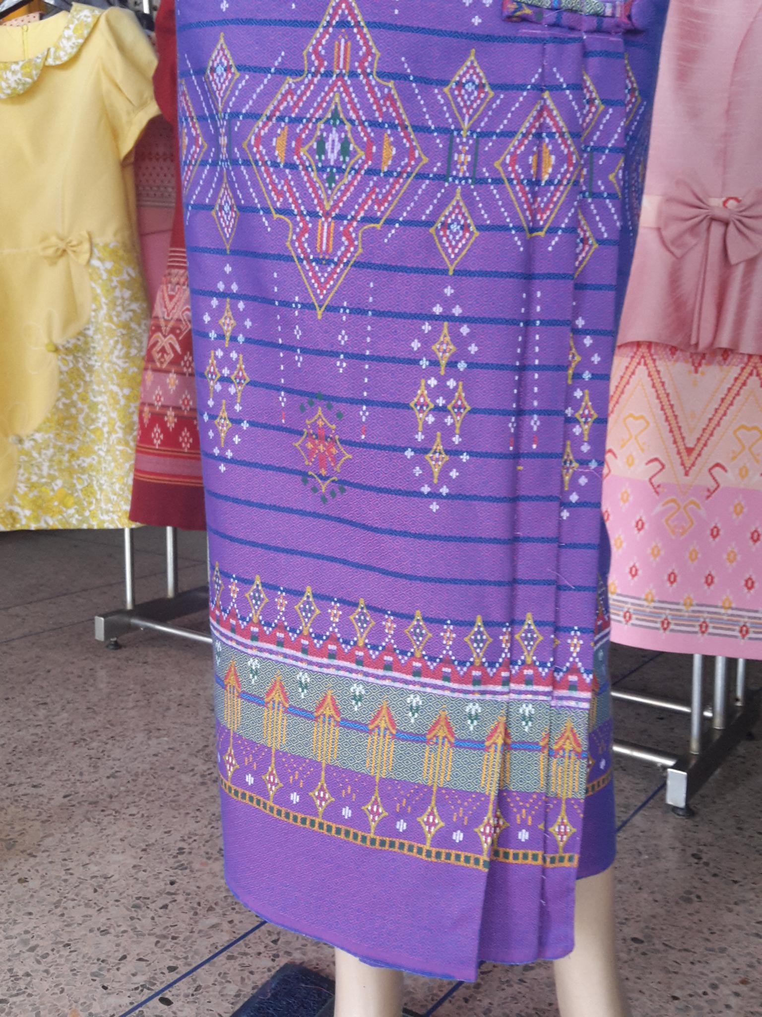 ผ้าซิ่นสำเร็จรูปผ้าซิ่นผ้าฝ้าย แบบป้ายแต่งจีบกระดุมปั้มลายเทพพนม ผ้าซิ่นตัดสำเร็จลายเทพพนมสีม่วง